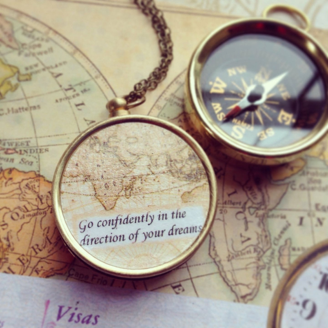 A brass compass resting on an antique map — Go confidently in the direction of your dreams